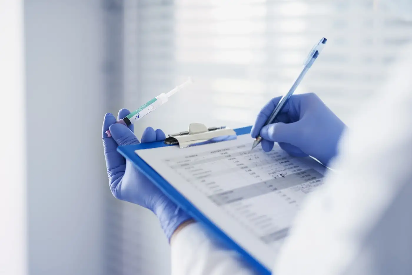 Medical professional recording clinical data on a clipboard