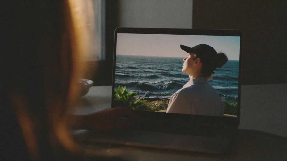 Office worker glancing up from a laptop toward a dim room, mid-refocus