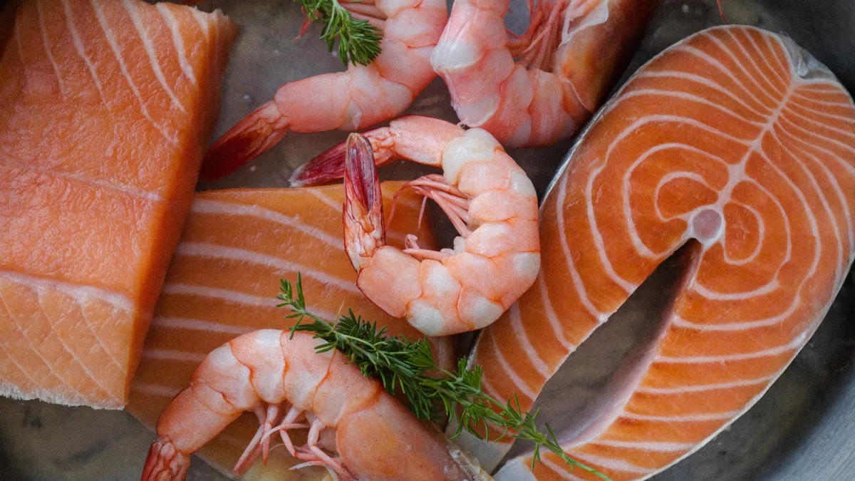 Fresh salmon fillets and pink shrimp on ice, showing the deep salmon-pink color