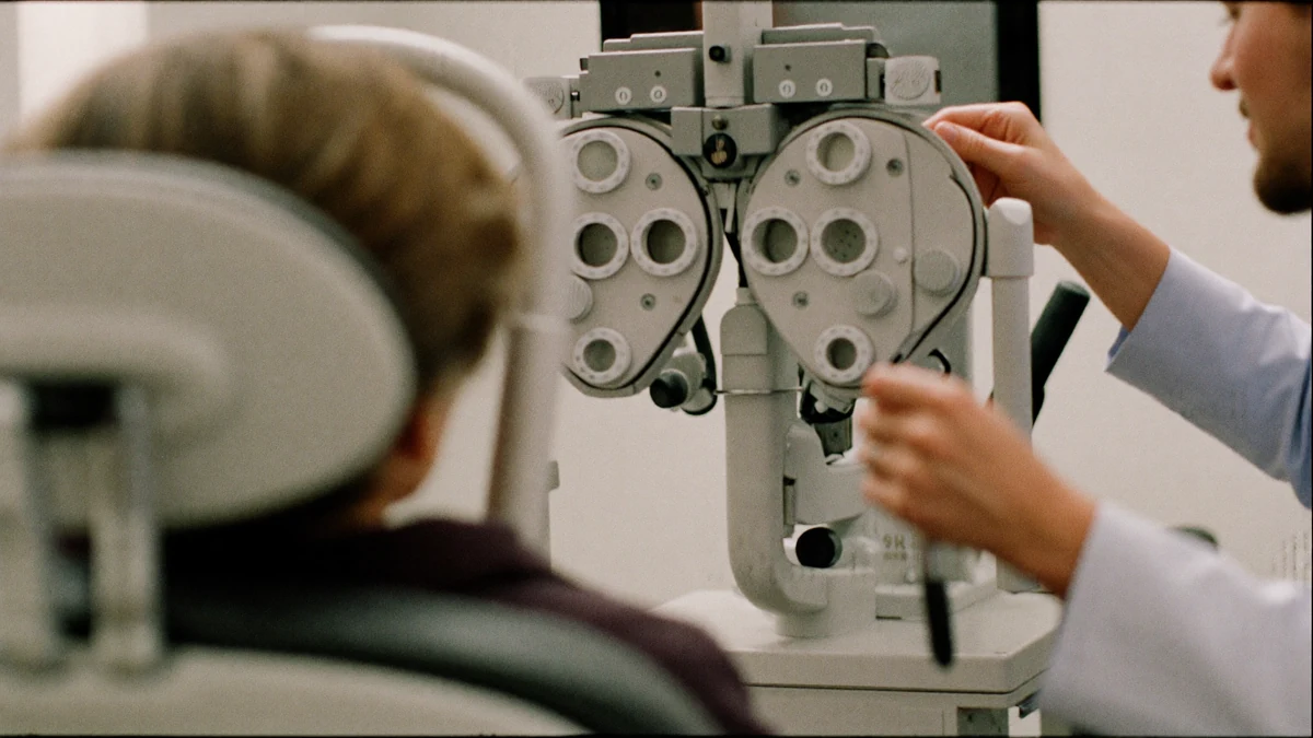 Older patient in an optometry exam chair facing an eye-testing device